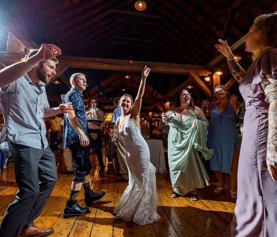 Happy wedding guests dancing and celebrating at Vermont wedding venue.