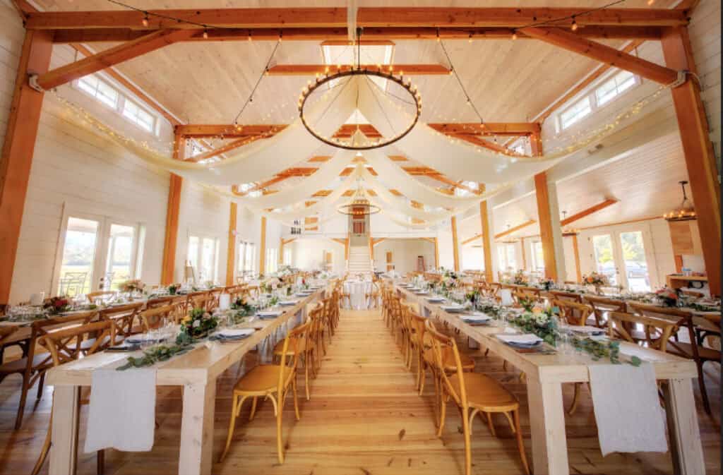 Elegant wedding reception setup in a rustic barn at Smugglers Notch.