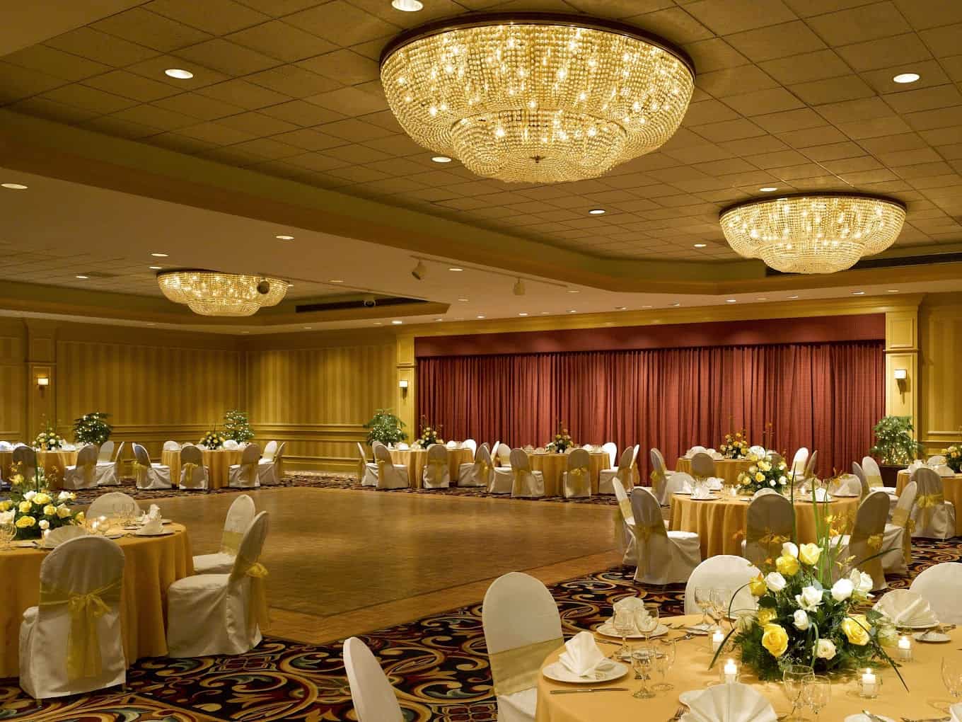 Elegant wedding reception setup with round tables and floral centerpieces.