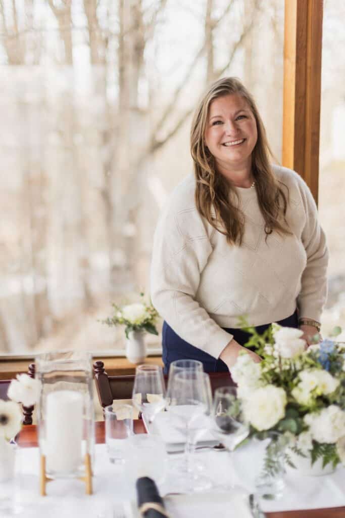 Smiling woman at wedding reception table in Vermont during daytime.
