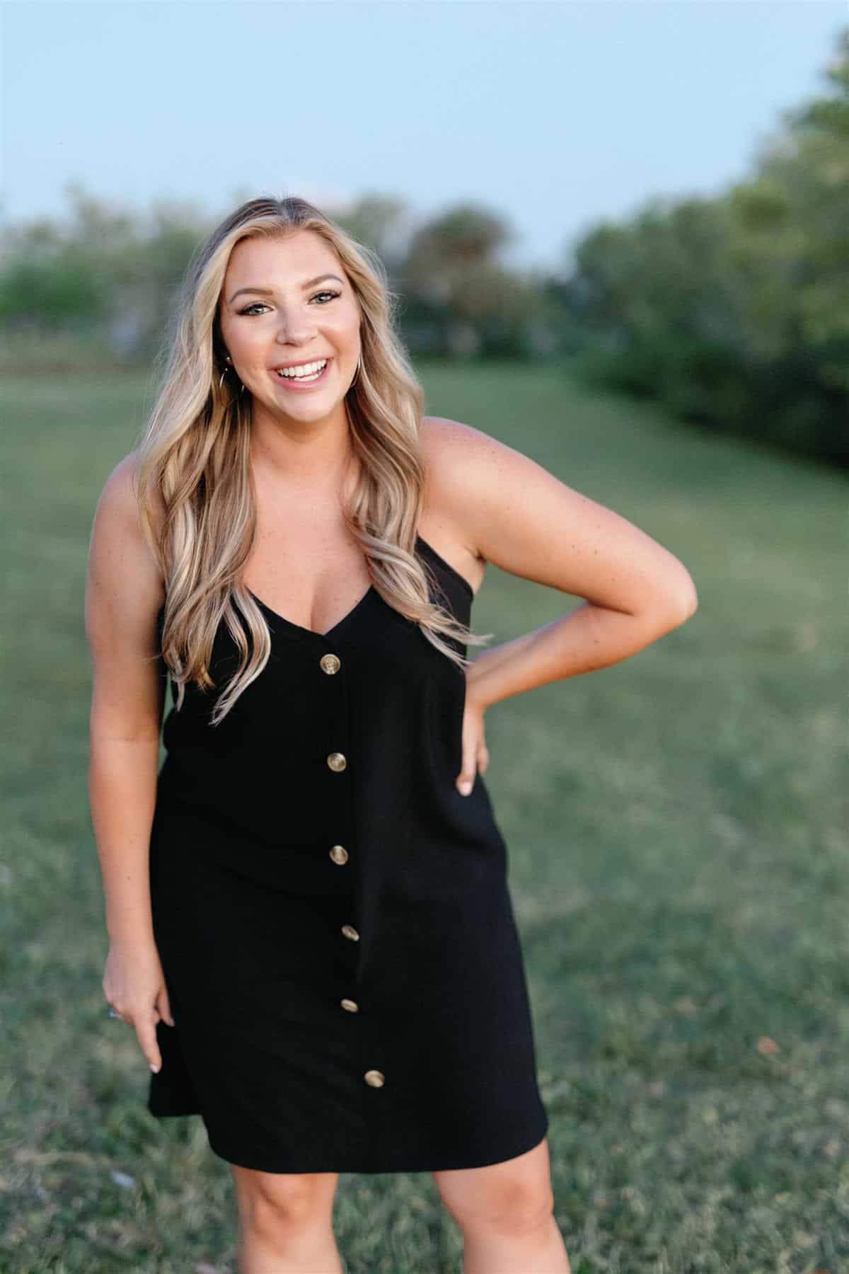 Smiling woman in black dress outdoors, Vermont wedding professional.