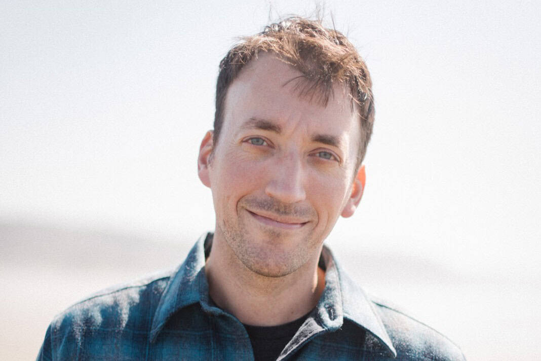 Portrait of a smiling man in casual attire outdoors in Vermont.