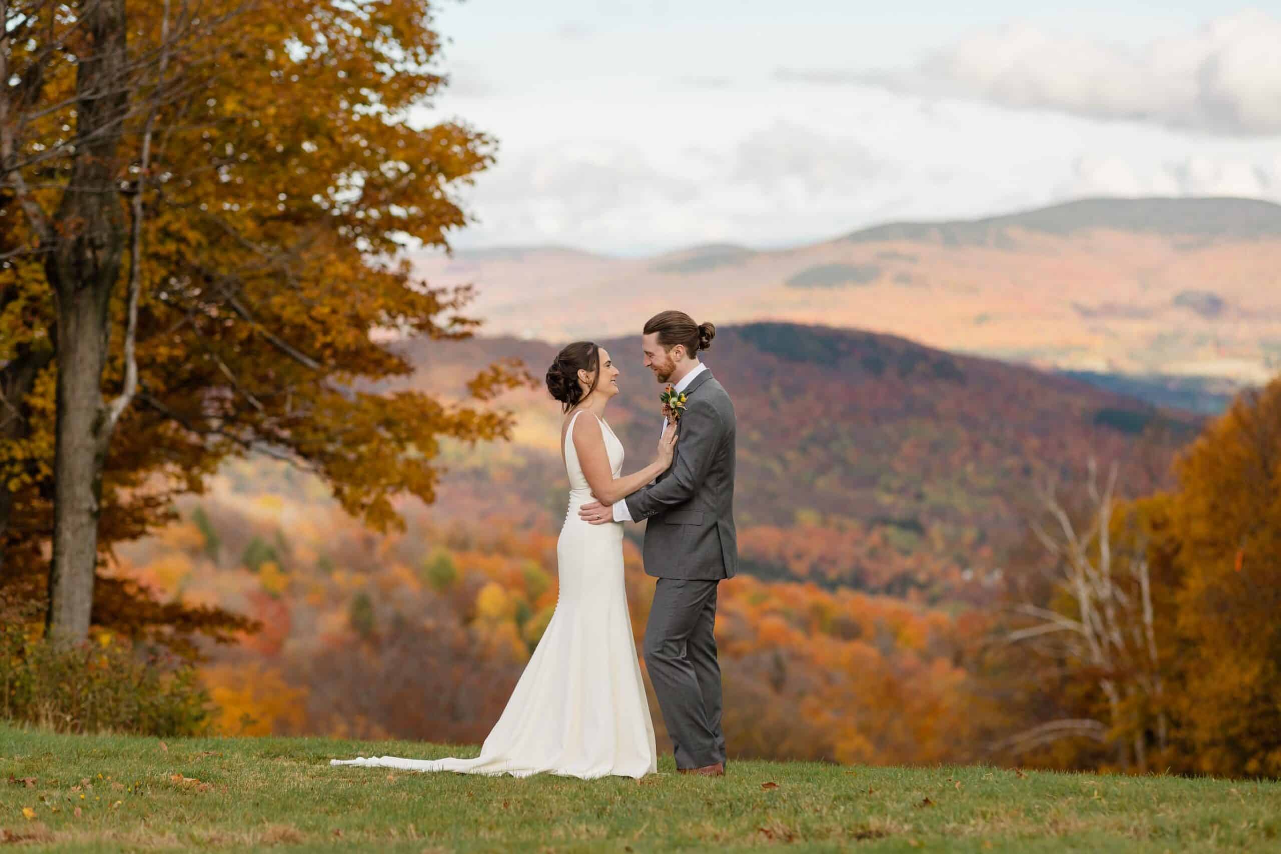 Bride and groom exchanging vows outdoors in fall at Sugarbush Resort.