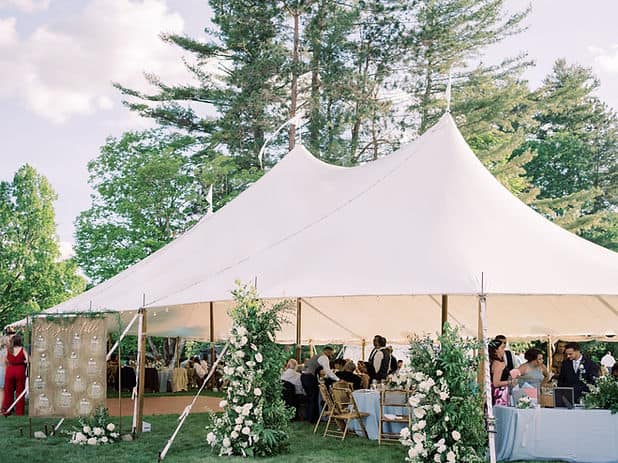Large white wedding tent with floral decorations in Vermont outdoor setting.