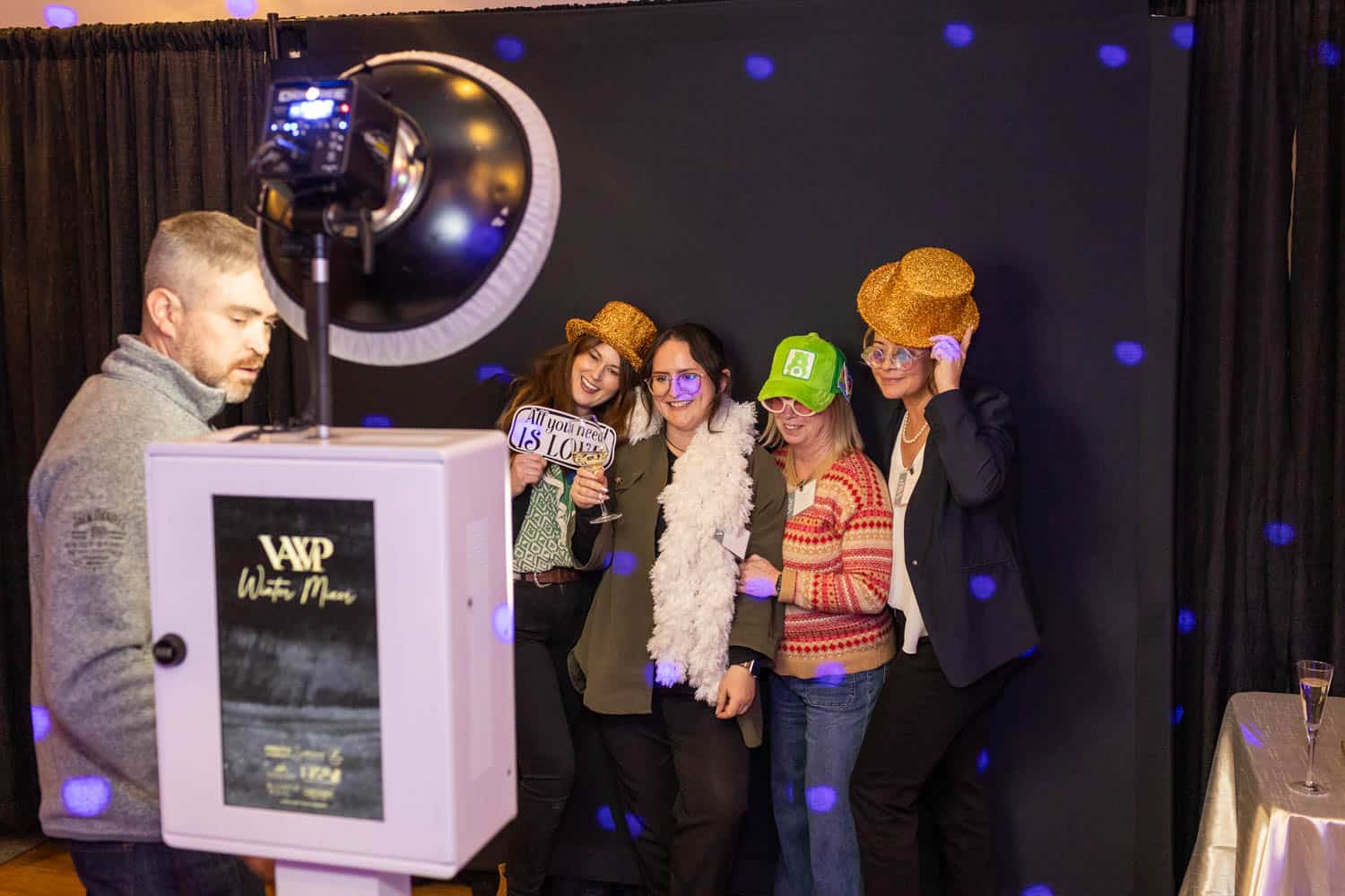 Group of wedding professionals posing with fun props at Vermont event.