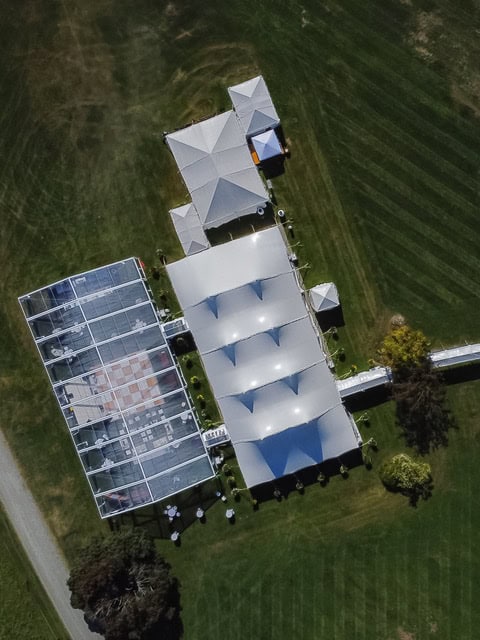 Aerial view of a wedding tent and reception area in Vermont.