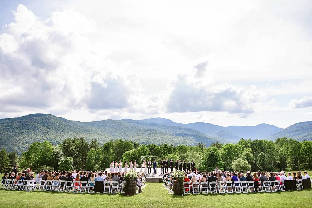 Guests attending outdoor wedding ceremony with mountain backdrop in Vermont.